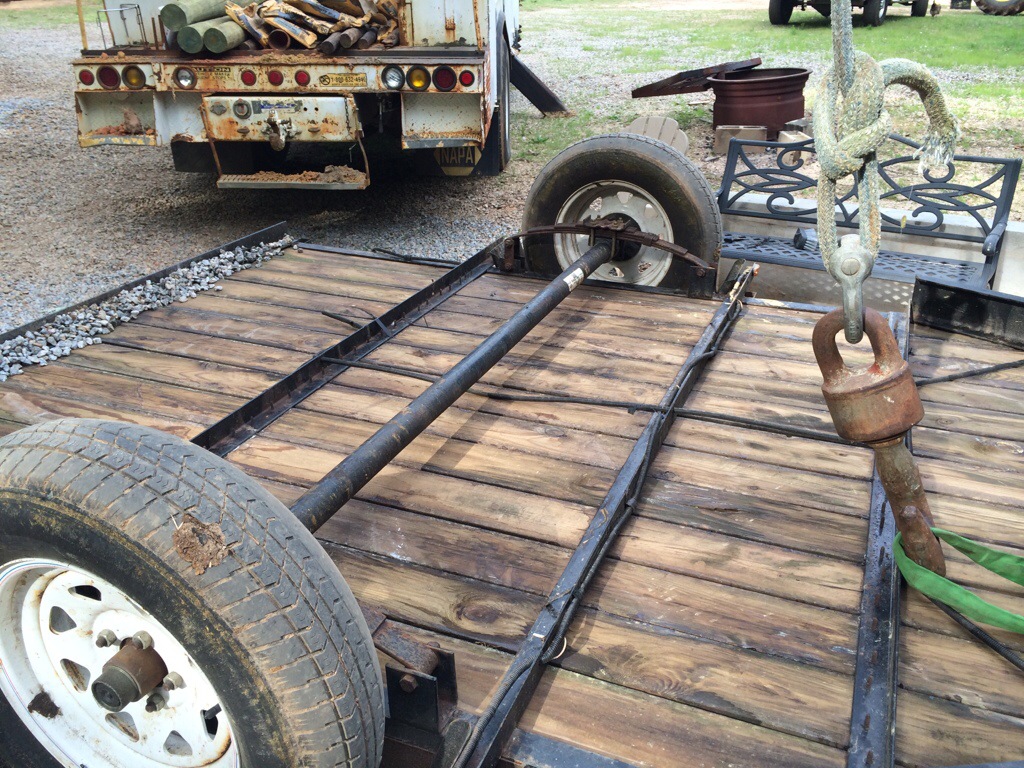 The trailer, flipped upside down. Here you see the worn tires and bent axle.