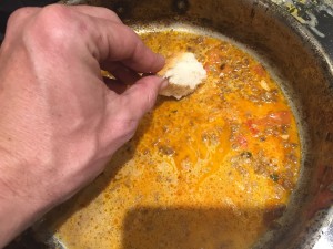 Sopping up broth in a pan on the stove