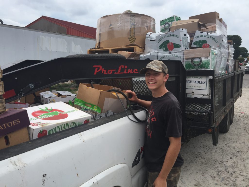 Adam standing beside a loaded truck and trailer