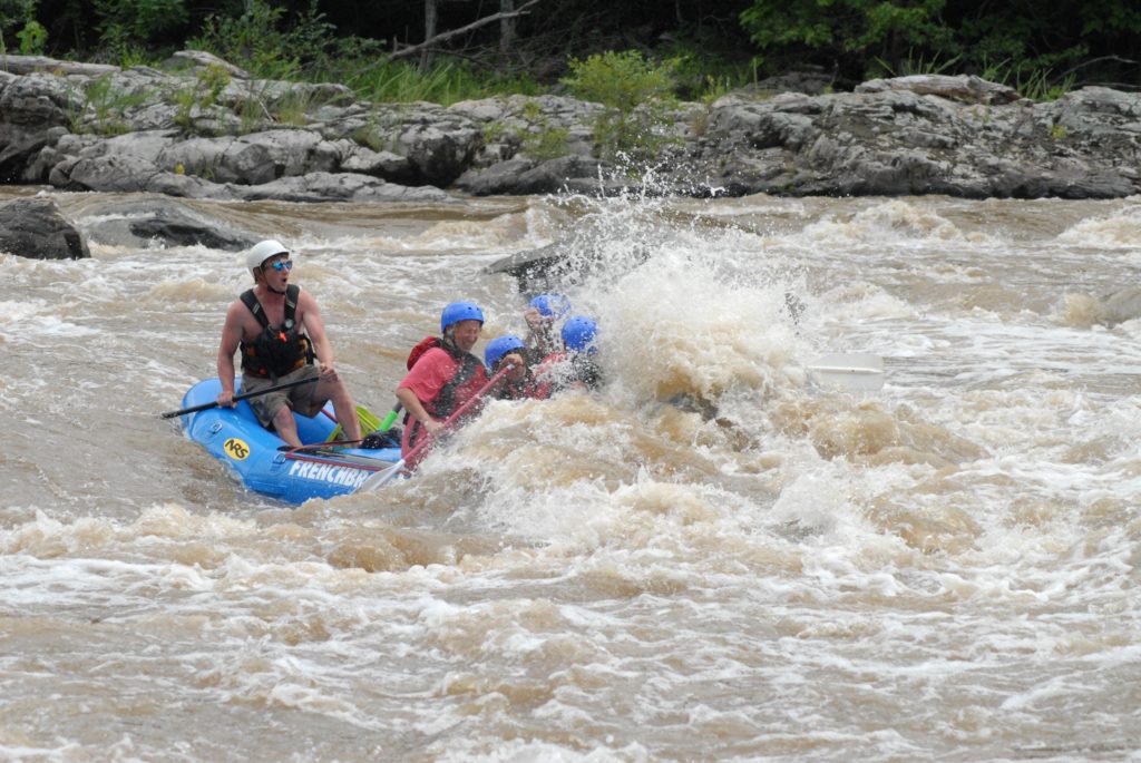 The Moore family, white water rafting and covered in water.
