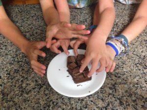 Kids grabbing fudge from a plate.