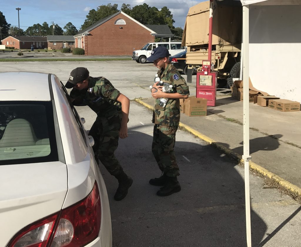 Two Civil air patrol cadets handing out water and food at a POD