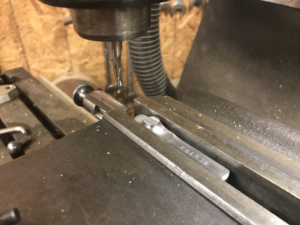 Machining flat the rough cut face of a bolt