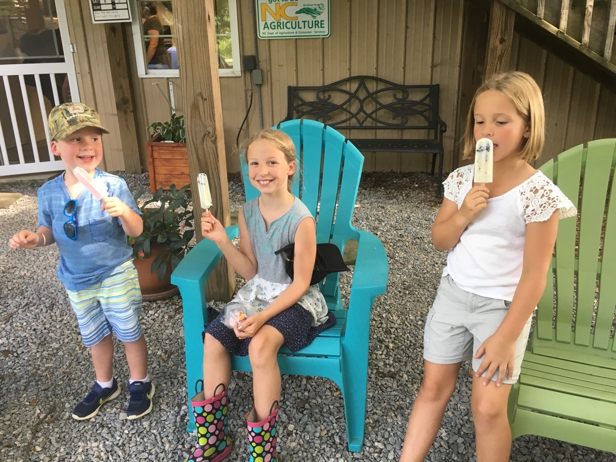 Kids eating locopops in front of the store.