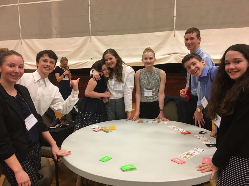 Kids dressed up standing around a table at speech and debate