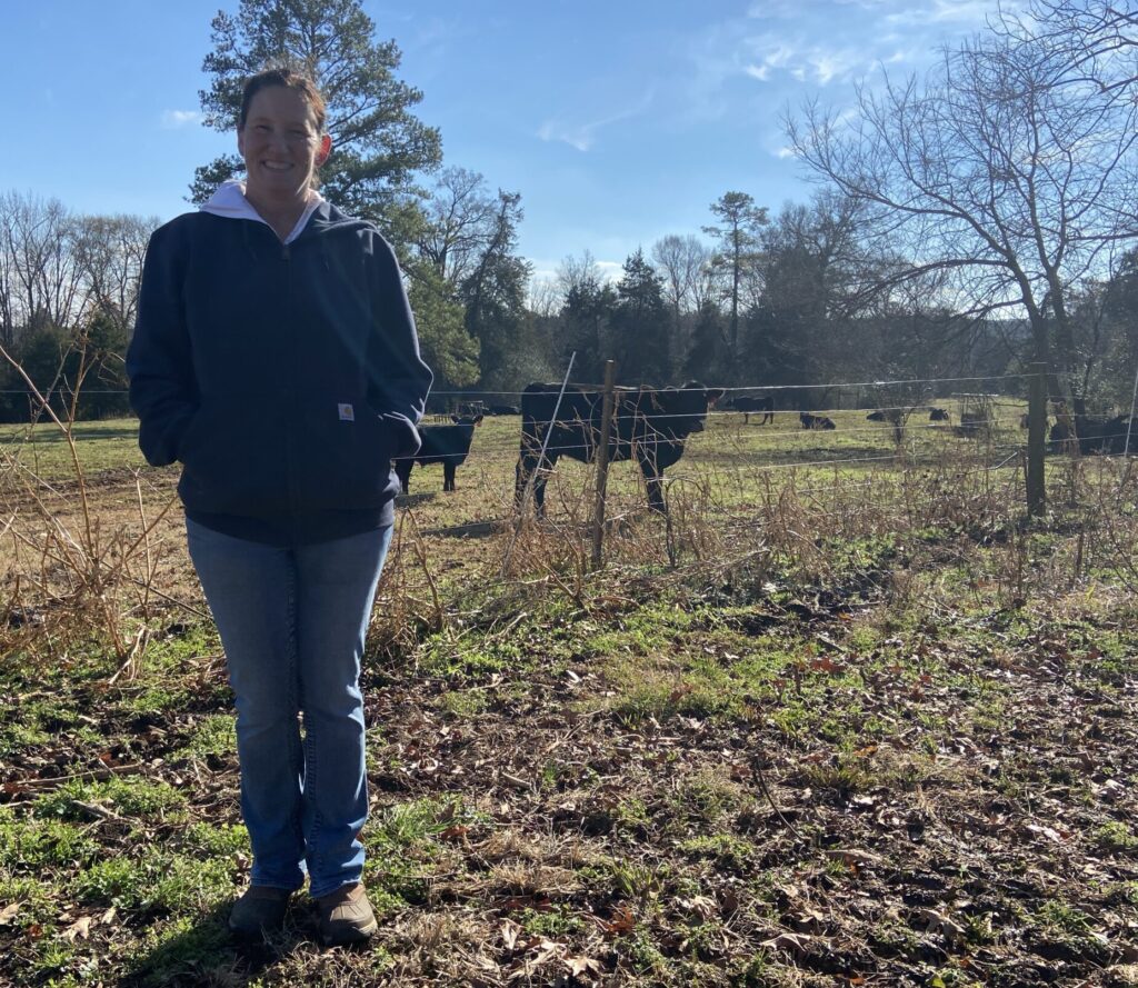 Elissa standing in front of some of her cows